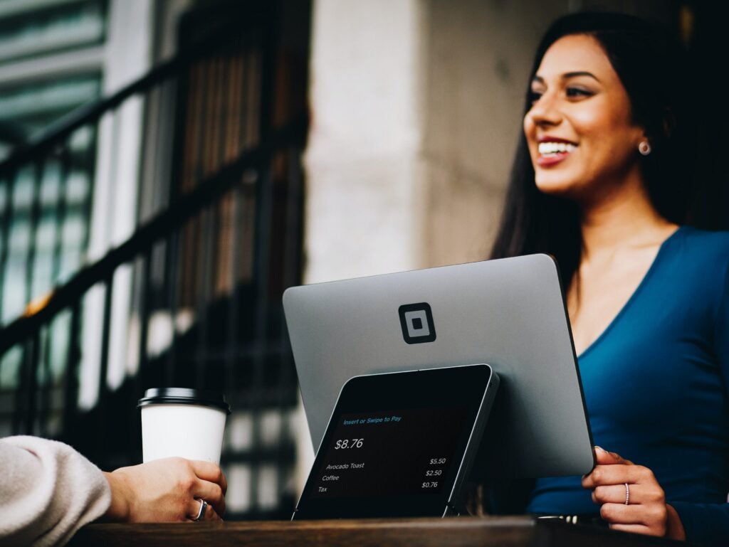 Une femme heureuse travaille sur une tablette dans un environnement professionnel