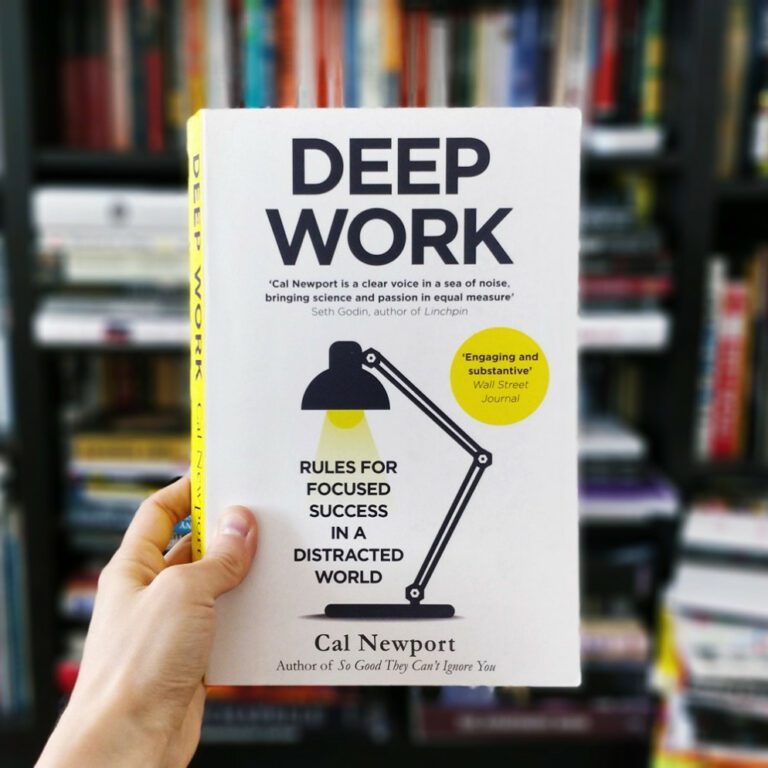 Hand holds up the book 'Deep Work' by Cal Newport