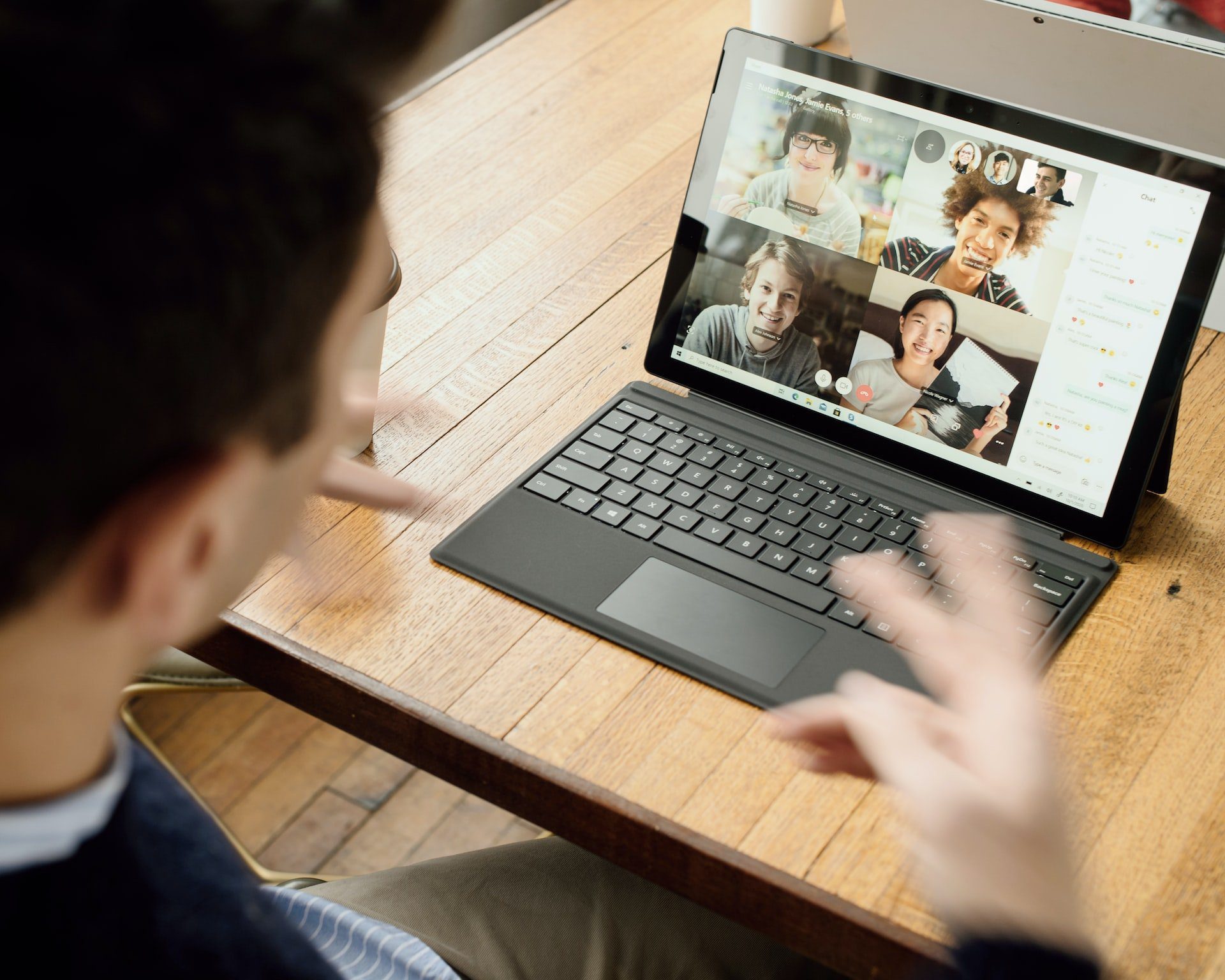 Man sits at desk and talks in online meeting on his laptop