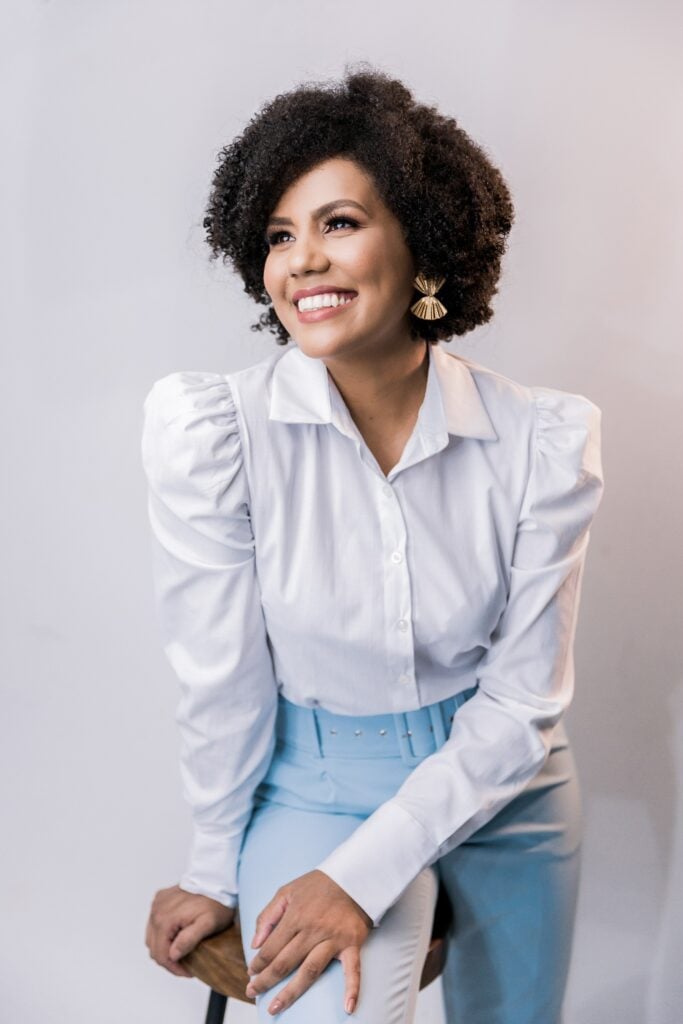 Happy woman in white blouse and light blue trousers