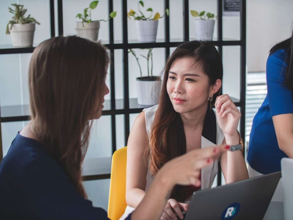 Colleagues discuss work in office