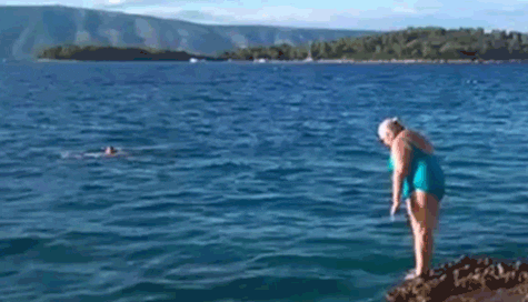 Older woman dives clumsily into water