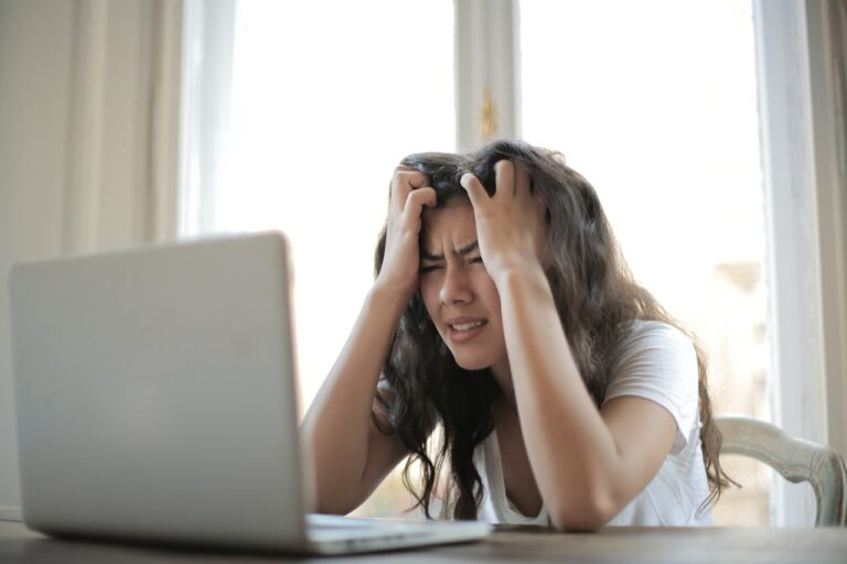 Une femme frustrée fixe son ordinateur portable