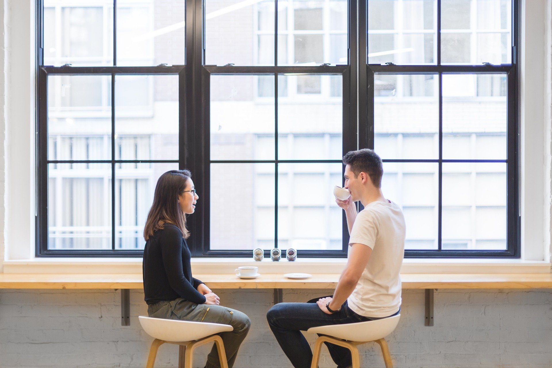 dos individuos compartiendo un café en una habitación luminosa