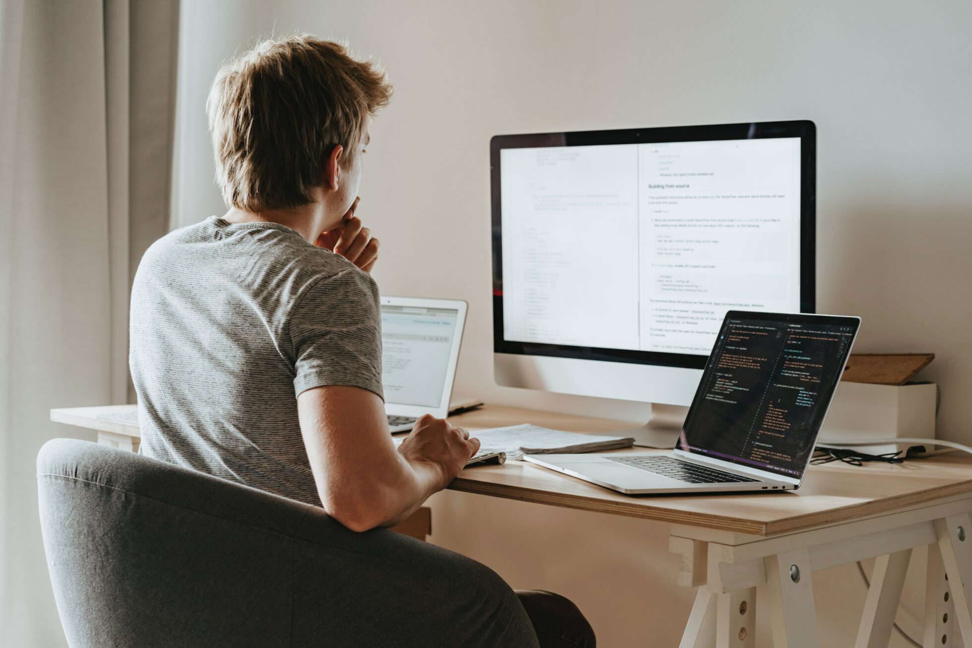 man sat in front of three computers