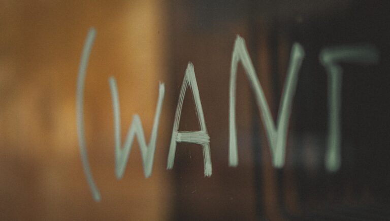Abbildung des Wortes "want" auf einer reflektierenden Oberfläche