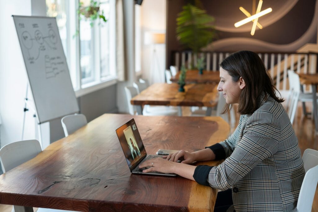 imagen de una persona sentada en un escritorio realizando una entrevista a un usuario con una pizarra blanca de fondo