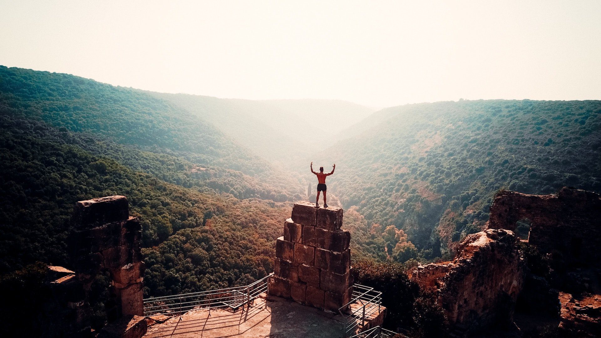 individual standing on top of a mountain winning