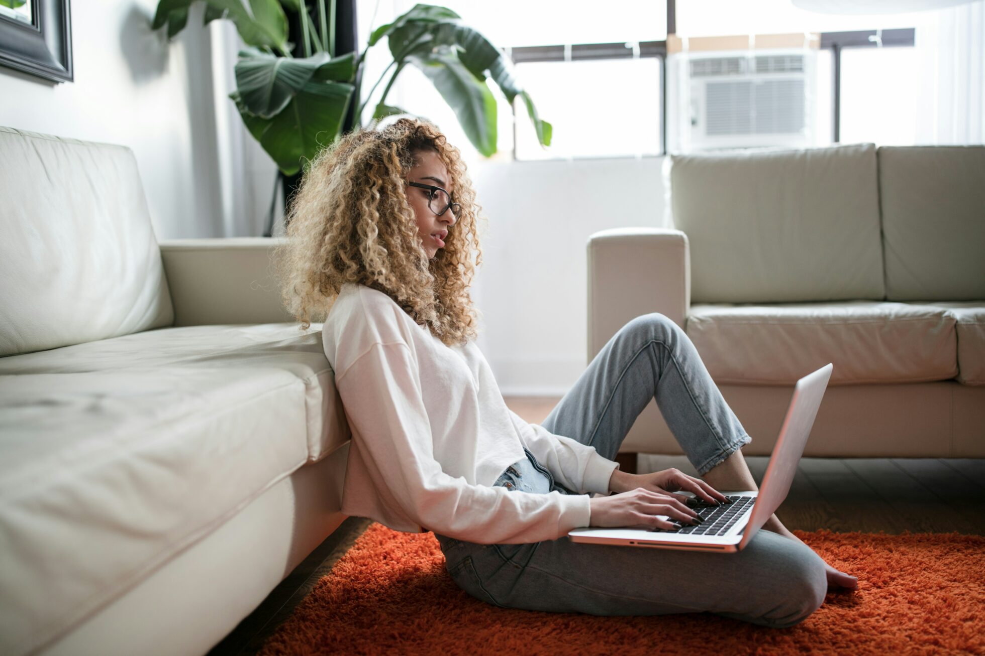 woman sat on the floor with a laptop looking at a performance improvement plan